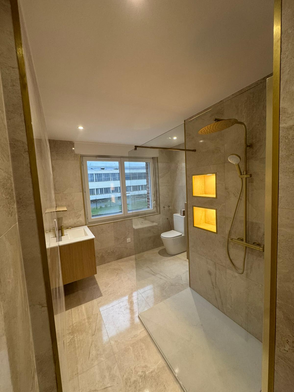 Salle de bain rénovée avec marbre et finitions dorées