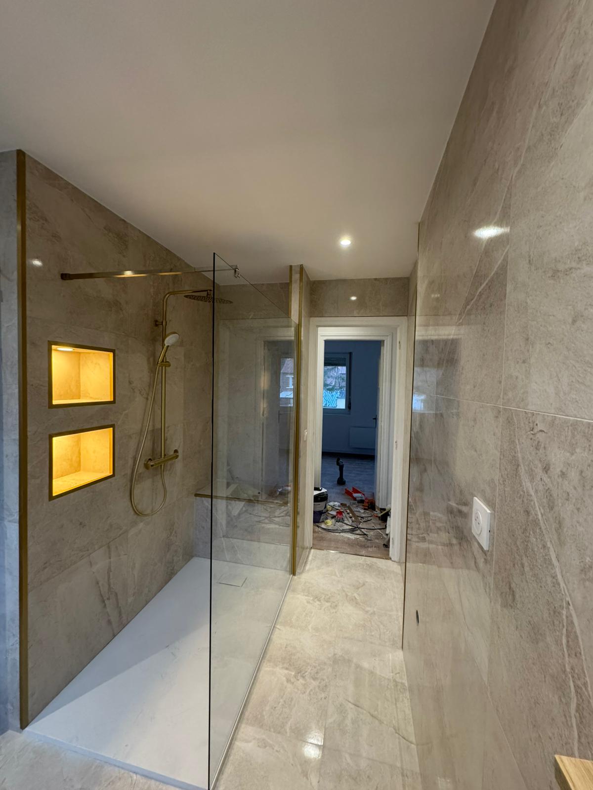 Douche à l’italienne avec niches rétroéclairées et profilés laiton